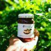Photo of Bolmay hazelnut chocolate spread in hand with greenery background